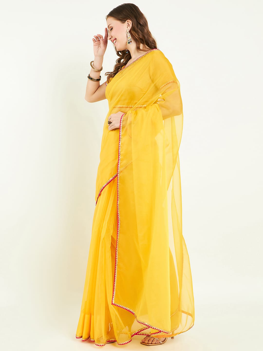 Organza saree with contrast border comes with blouse and lace detailing.