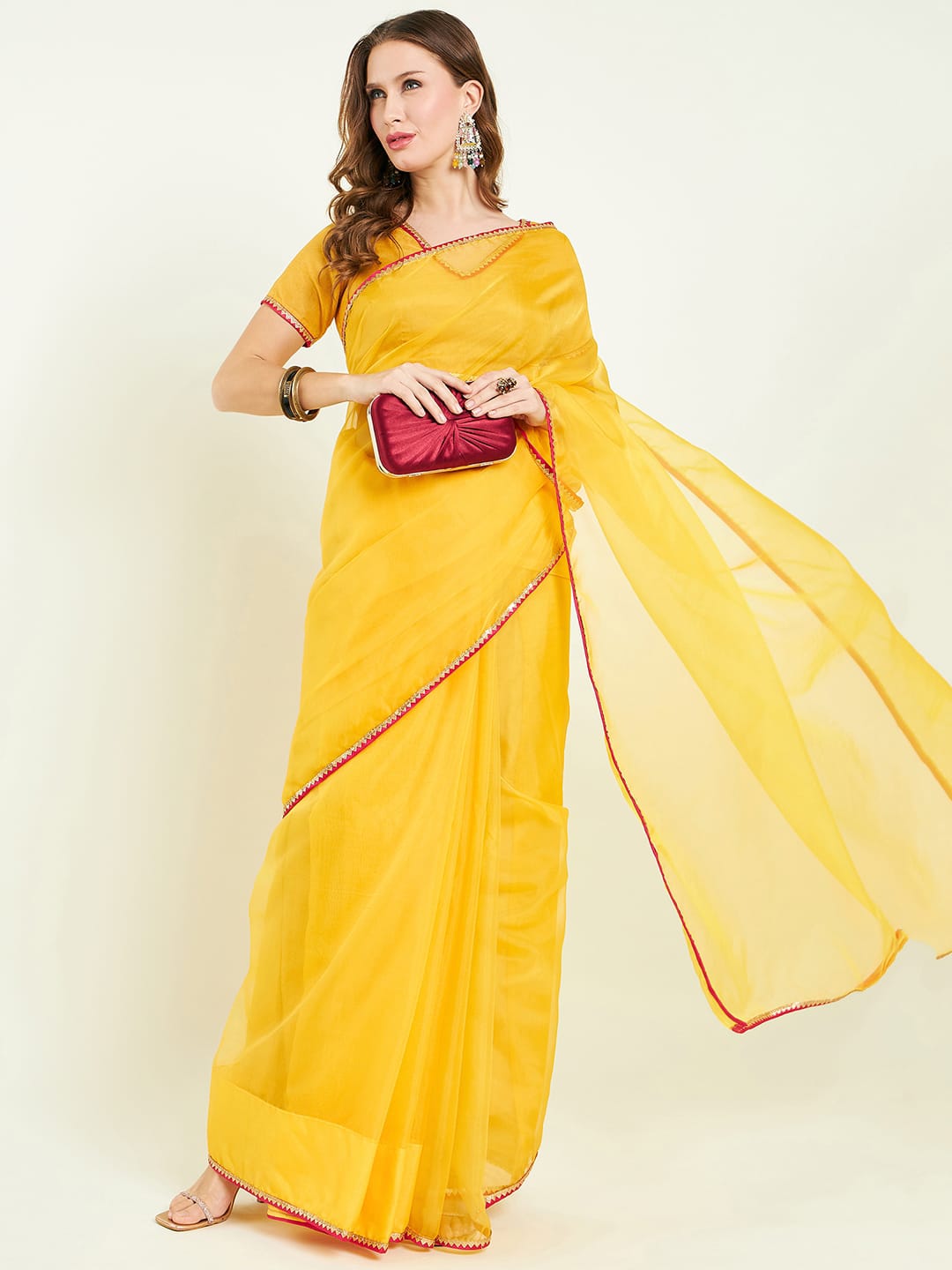 Organza saree with contrast border comes with blouse and lace detailing.