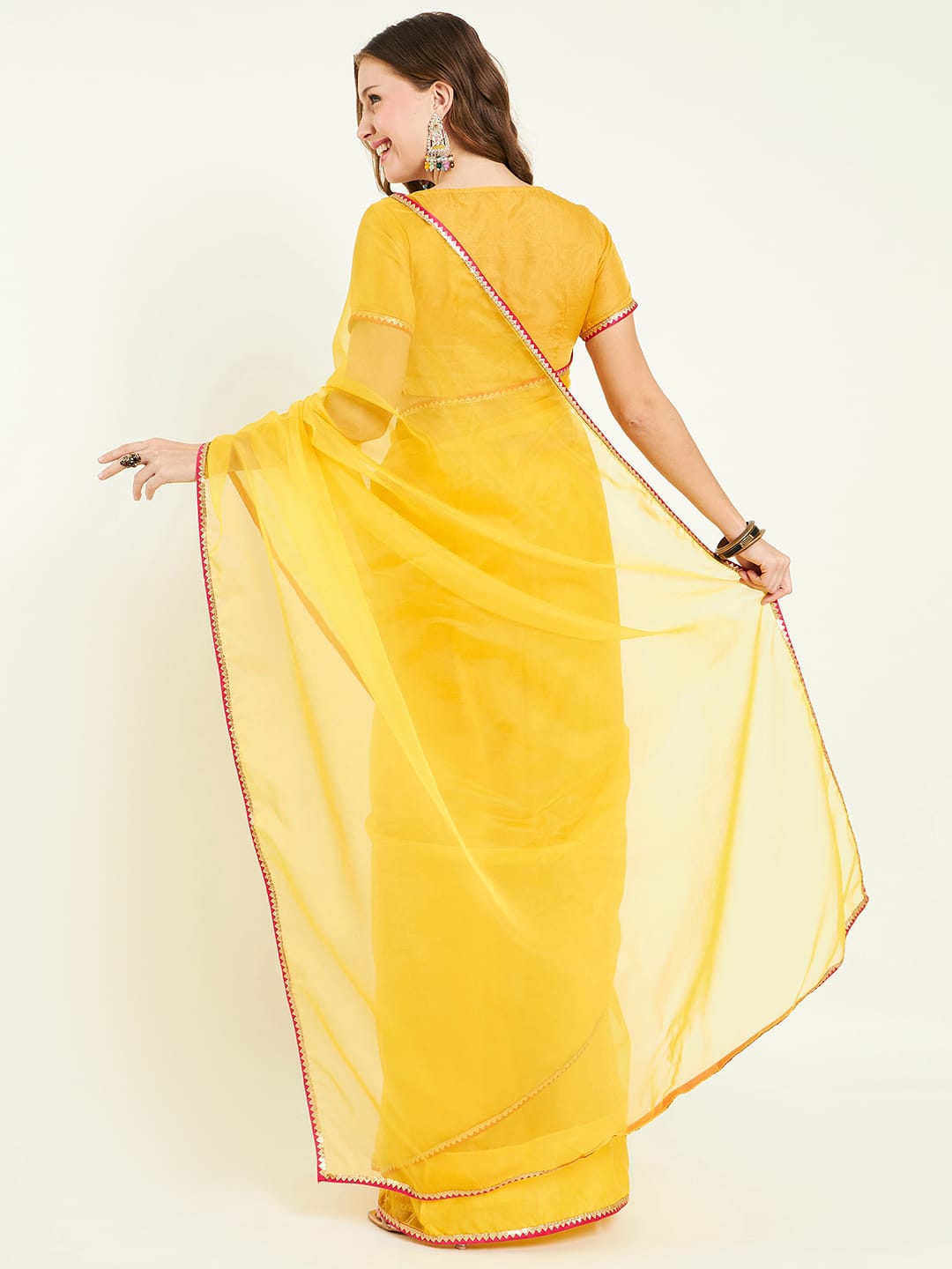 Organza saree with contrast border comes with blouse and lace detailing.