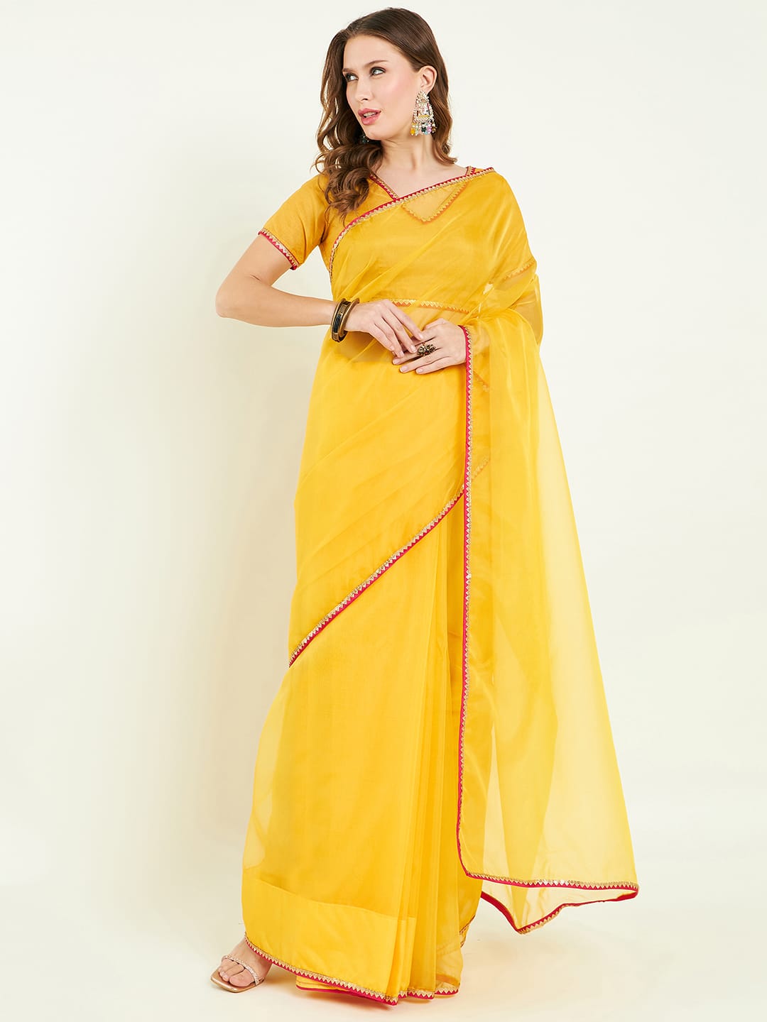 Organza saree with contrast border comes with blouse and lace detailing.